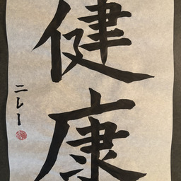 vertically written japanese calligraphy in black ink on white paper, with a signature and red seal on the left side